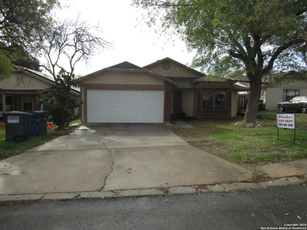 a view of a house with a yard and large tree
