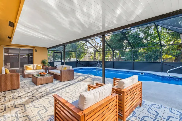 a living room with patio furniture and a floor to ceiling window
