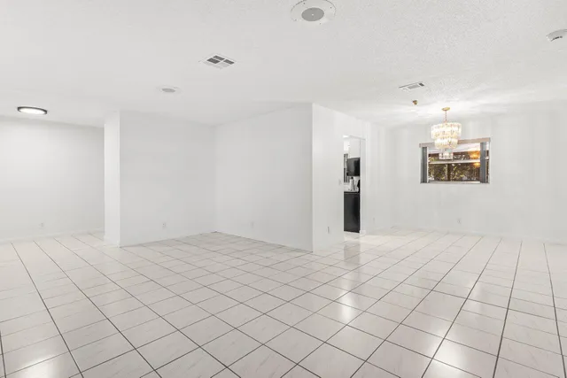 an empty room with windows and cabinet