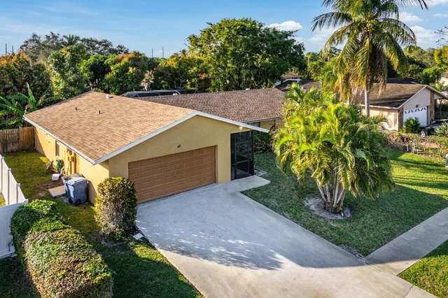 a aerial view of a house with a yard and potted plants