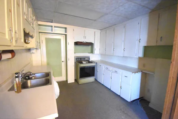 a kitchen with granite countertop a sink stove and refrigerator