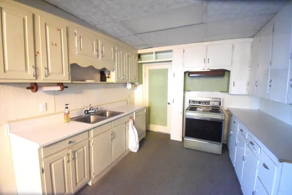 a kitchen with stainless steel appliances a stove a sink and a refrigerator