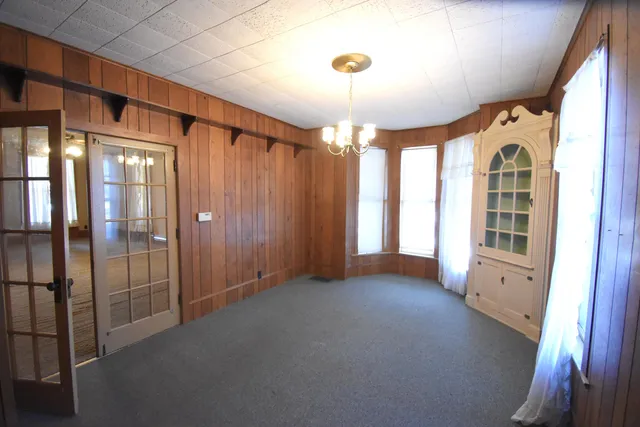 an empty room with a window and a ceiling fan