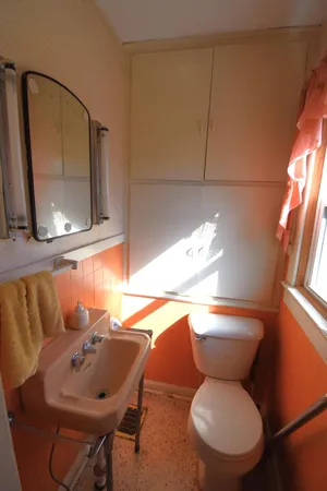 a bathroom with a toilet sink and mirror