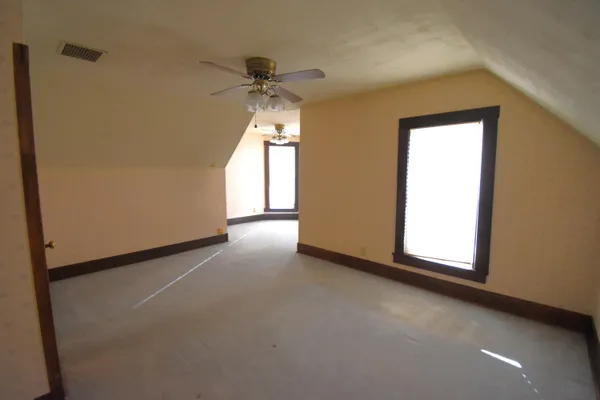 an empty room with a window and a ceiling fan