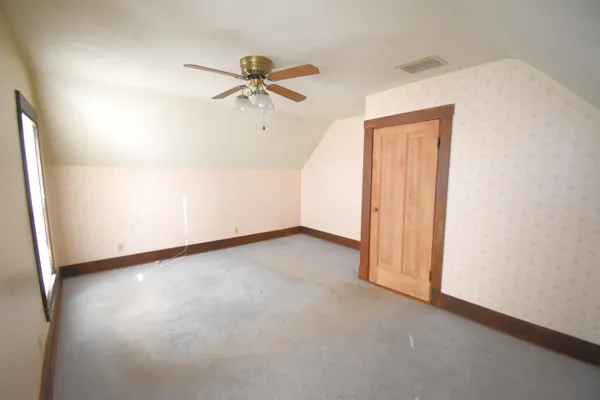 an empty room with a ceiling fan and wooden floor