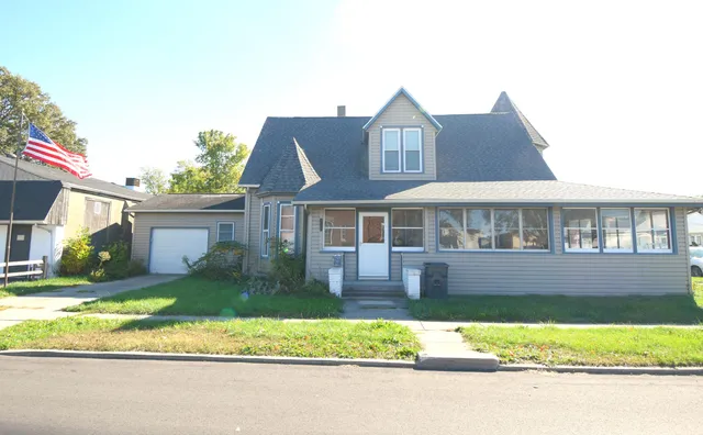 a front view of a house with a yard and potted plants