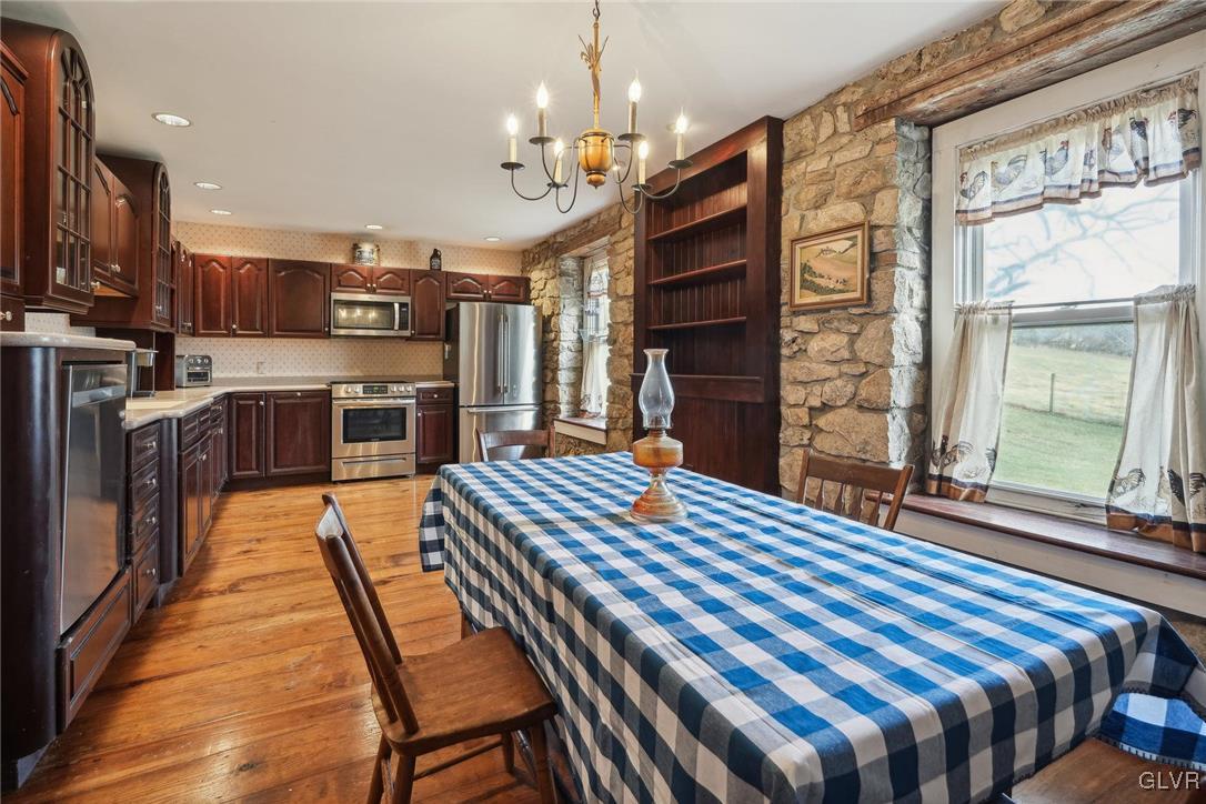 2426 Keeler Road Bath, PA 18014 - Photo 3 of 40 a outdoor kitchen with a stove a sink dishwasher a dining table and chairs with wooden floor