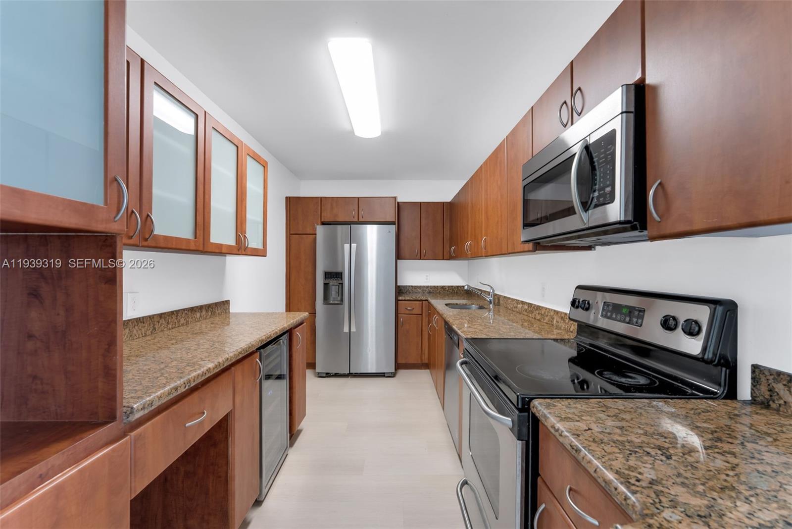 401 69th Street, Unit 1201 Miami Beach, FL 33141 - Photo 8 of 25 a kitchen with stainless steel appliances granite countertop a refrigerator a stove a sink and a microwave