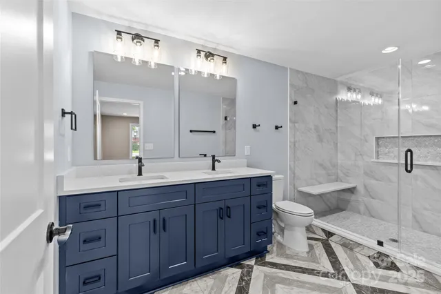 a spacious bathroom with a double vanity sink mirror double shower and a toilet