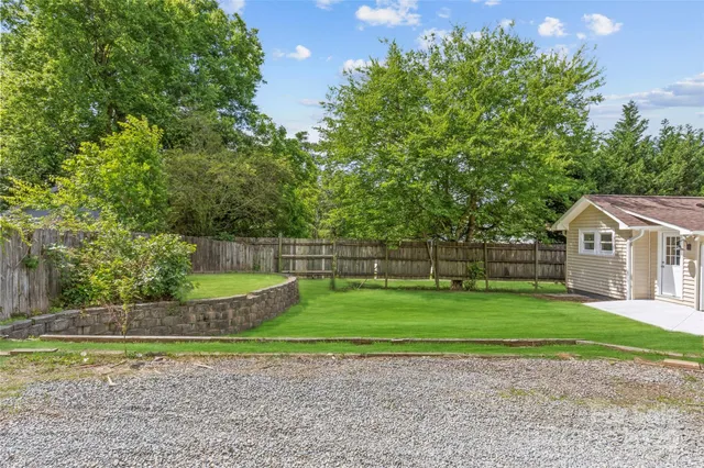 a view of a house with a yard and a large trees