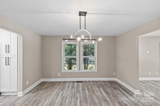 a view of empty room with wooden floor and outdoor view