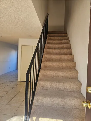 a view of a hallway with wooden floor and a bathroom