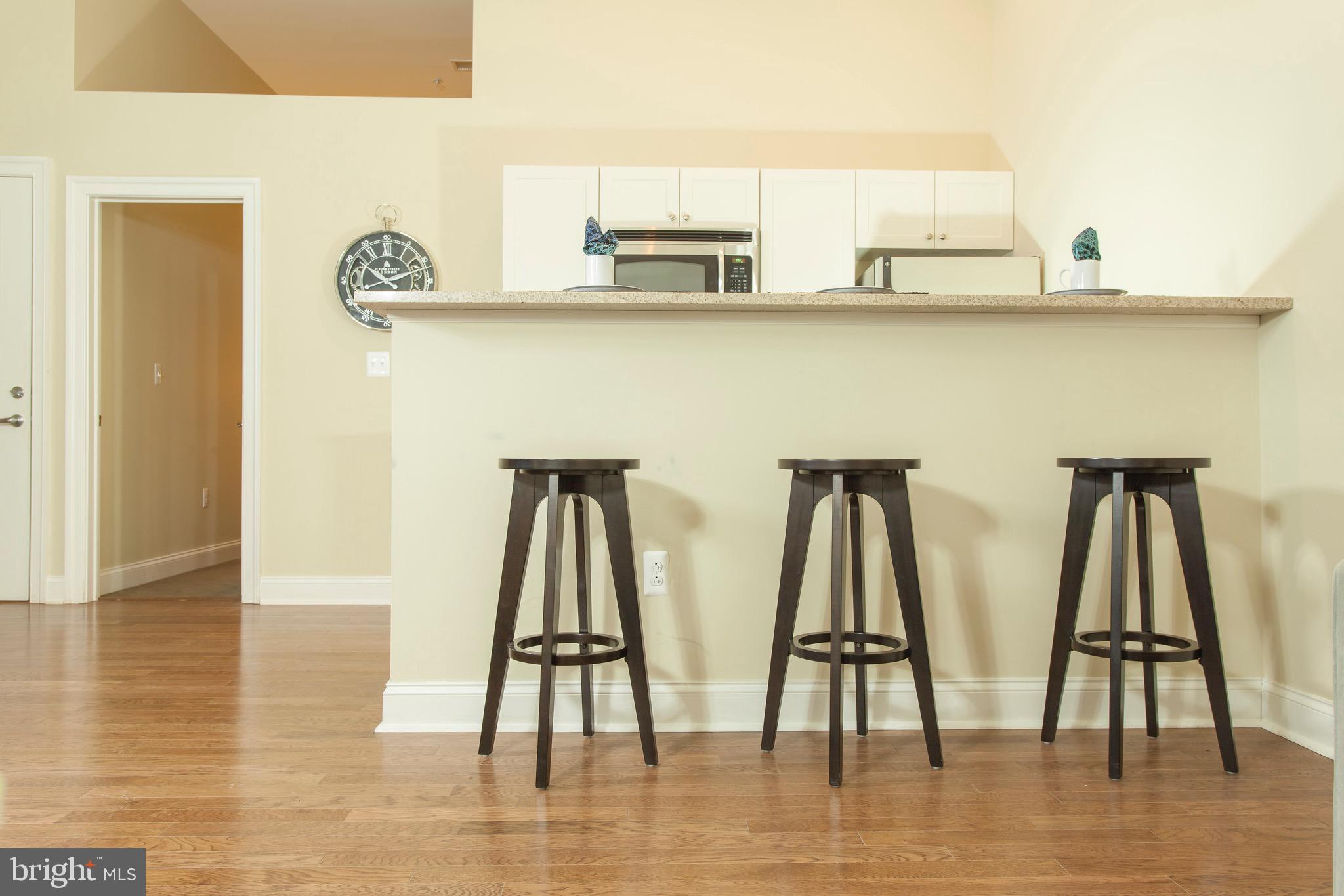 521 St Paul Street, Unit 3BR Baltimore, MD 21202 - Photo 22 of 44 a view of dining room with wooden floor and cabinets