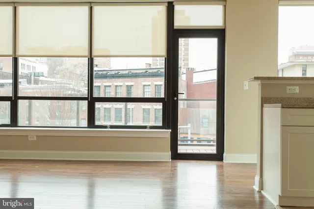 a view of a kitchen with refrigerator and wooden floor