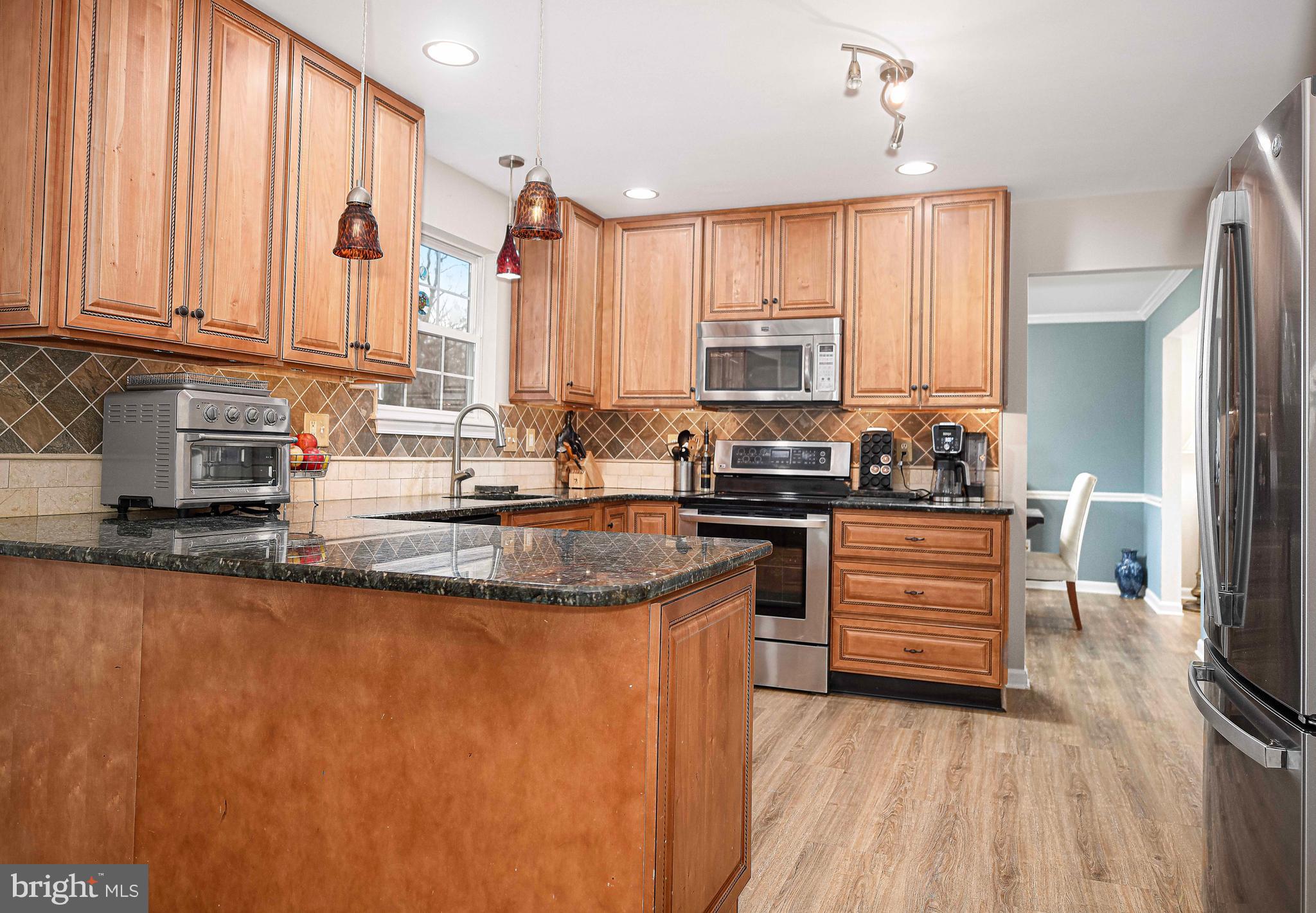 402 Hall Street Bel Air, MD 21014 - Photo 2 of 46 a kitchen with stainless steel appliances granite countertop a stove a sink a refrigerator and white cabinets with wooden floor