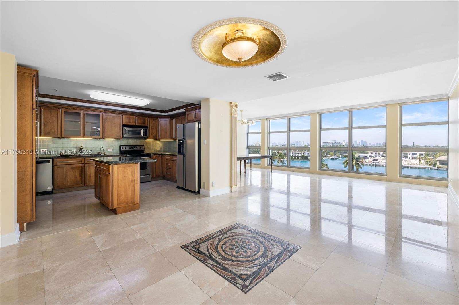5055 Collins Avenue, Unit 6M Miami Beach, FL 33140 - Photo 1 of 40 a kitchen with stainless steel appliances granite countertop a stove top oven a sink a dining table and chairs