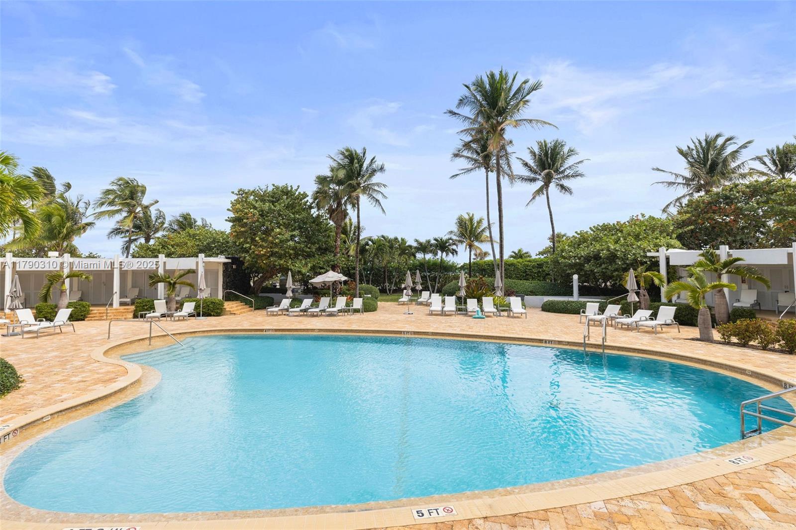 5055 Collins Avenue, Unit 6M Miami Beach, FL 33140 - Photo 31 of 40 a view of a swimming pool with a lawn chairs under an umbrella