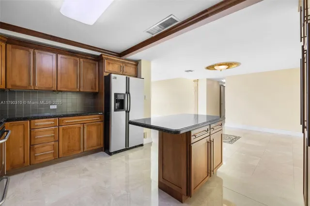 a kitchen with stainless steel appliances granite countertop a stove a refrigerator and a sink with granite countertops