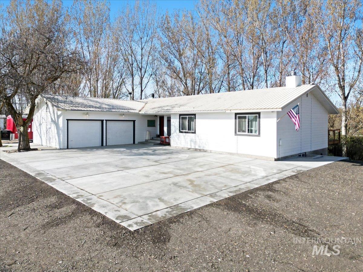 7771 Elmore Road Fruitland, ID 83619 - Photo 2 of 45 Single story home featuring a metal roof, a garage, a chimney, and driveway