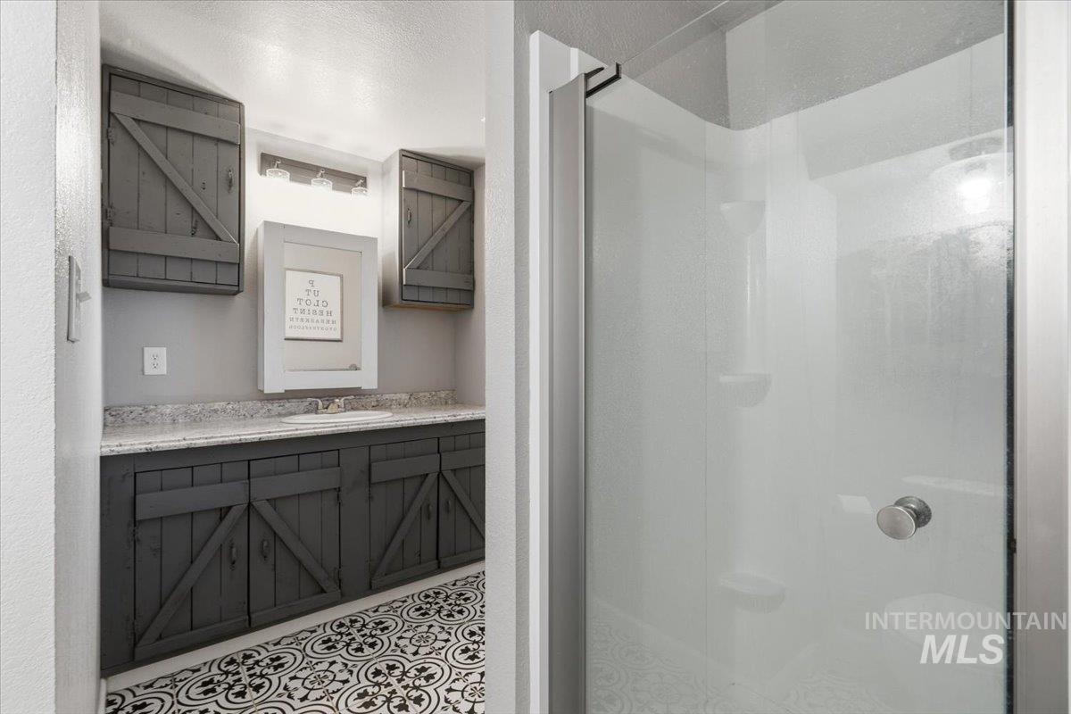 7771 Elmore Road Fruitland, ID 83619 - Photo 27 of 45 Bathroom featuring vanity, a stall shower, and light tile patterned floors