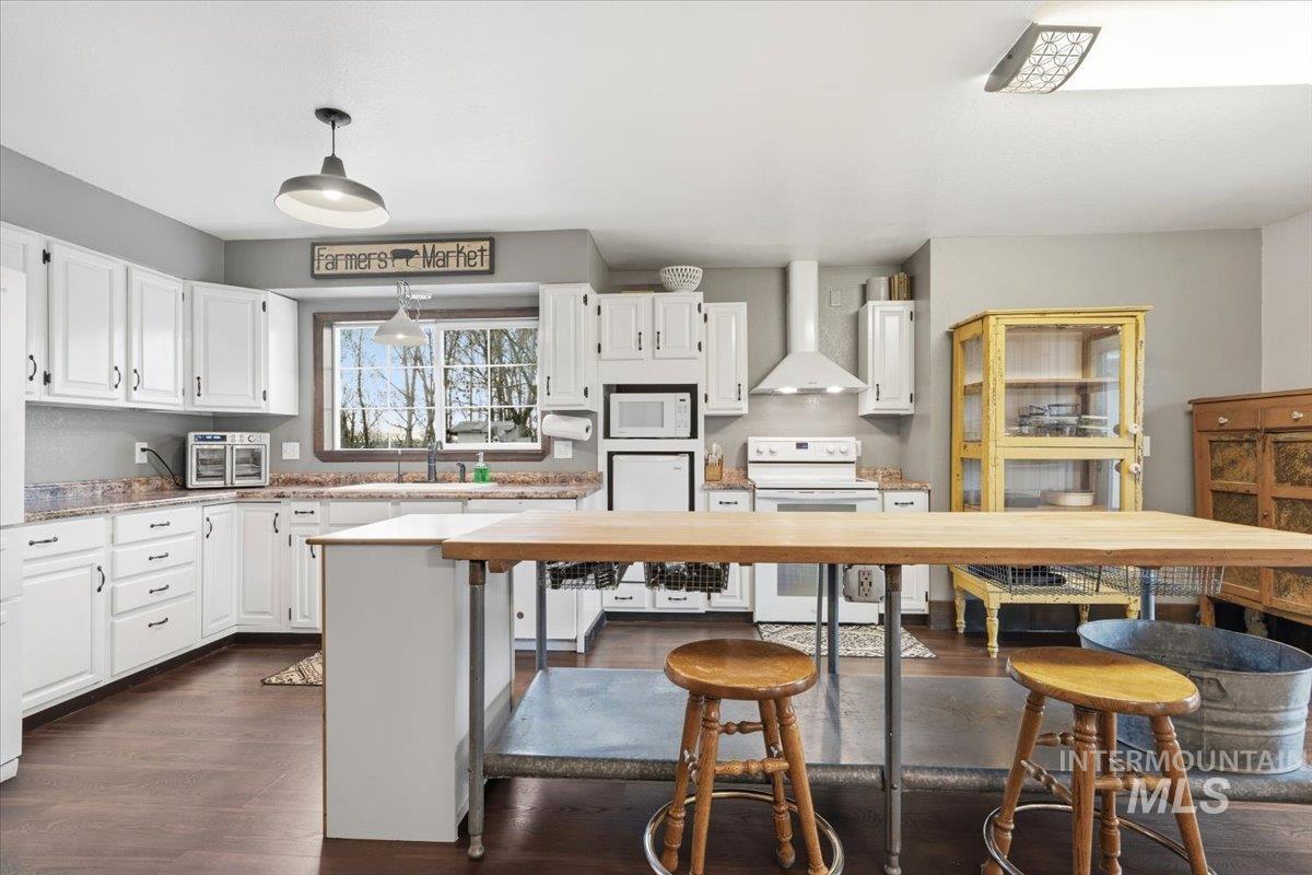 7771 Elmore Road Fruitland, ID 83619 - Photo 5 of 45 Kitchen featuring white cabinetry, white appliances, and dark wood-style floors