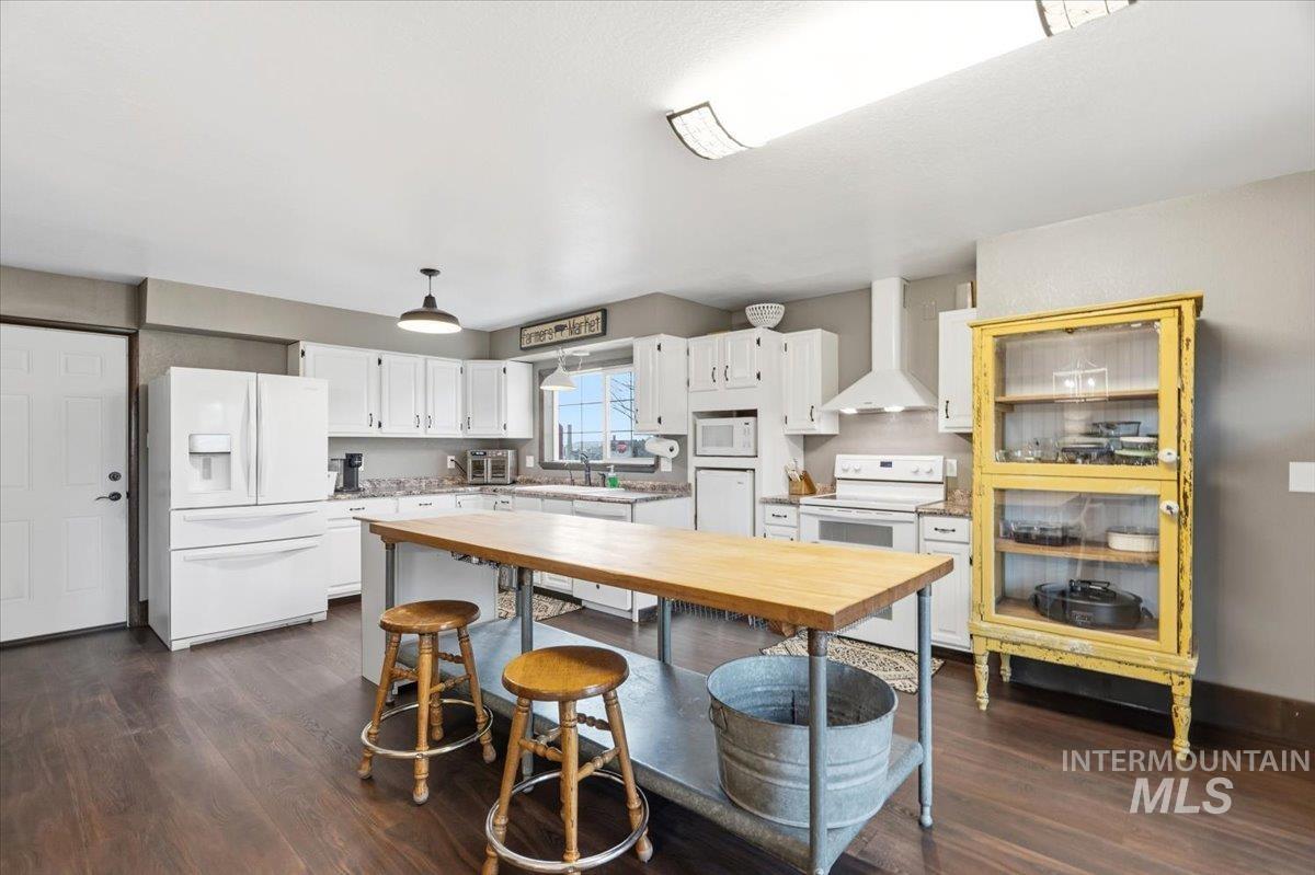7771 Elmore Road Fruitland, ID 83619 - Photo 8 of 45 Kitchen featuring white appliances, white cabinetry, and dark wood-type flooring