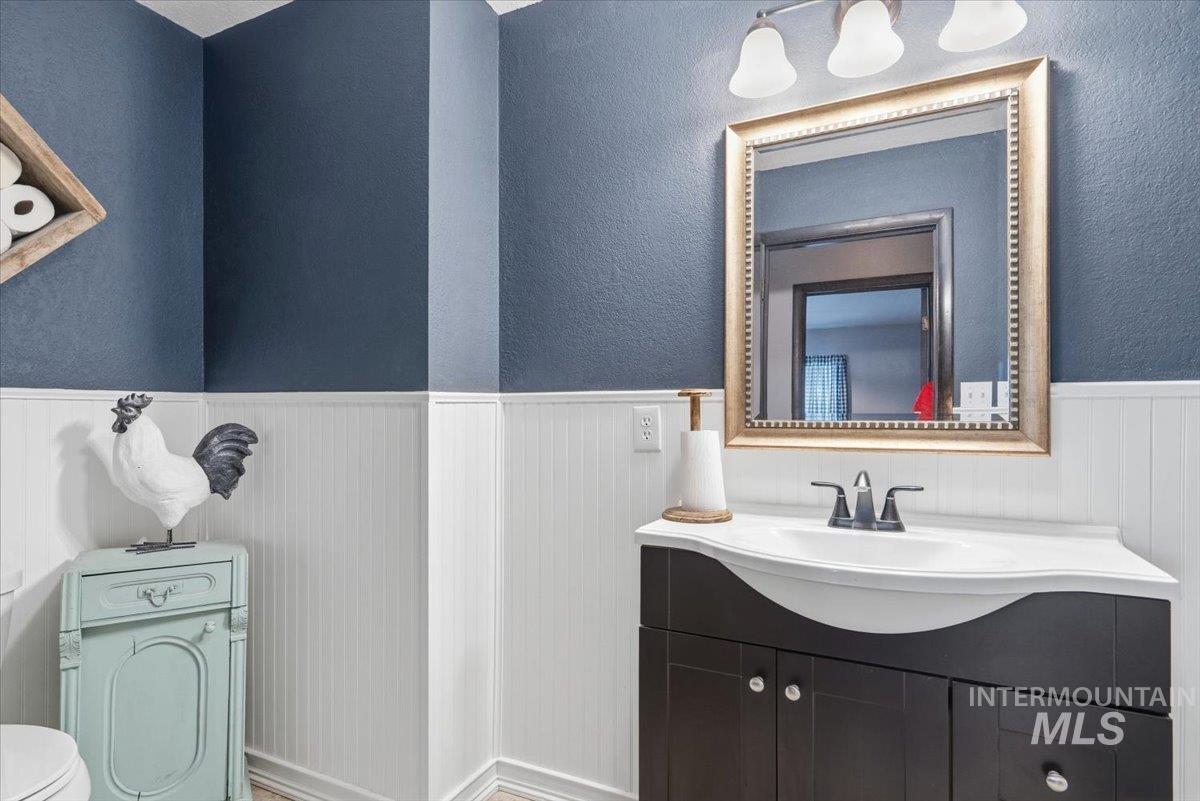 7771 Elmore Road Fruitland, ID 83619 - Photo 10 of 45 Bathroom with vanity, a wainscoted wall, and a textured wall