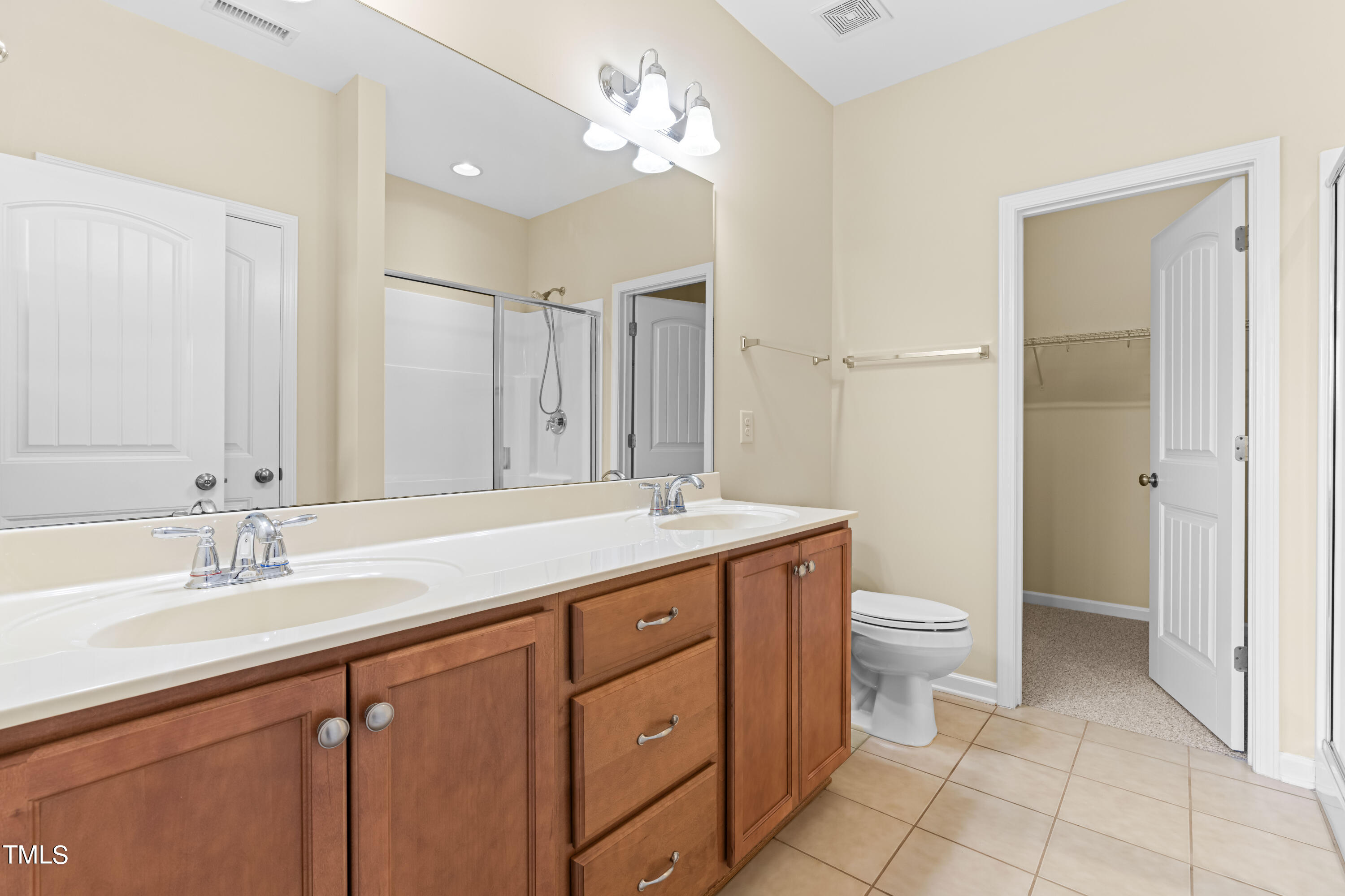 1305 Silver Beach Way Raleigh, NC 27606 - Photo 18 of 47 a bathroom with a double vanity sink a toilet and a mirror