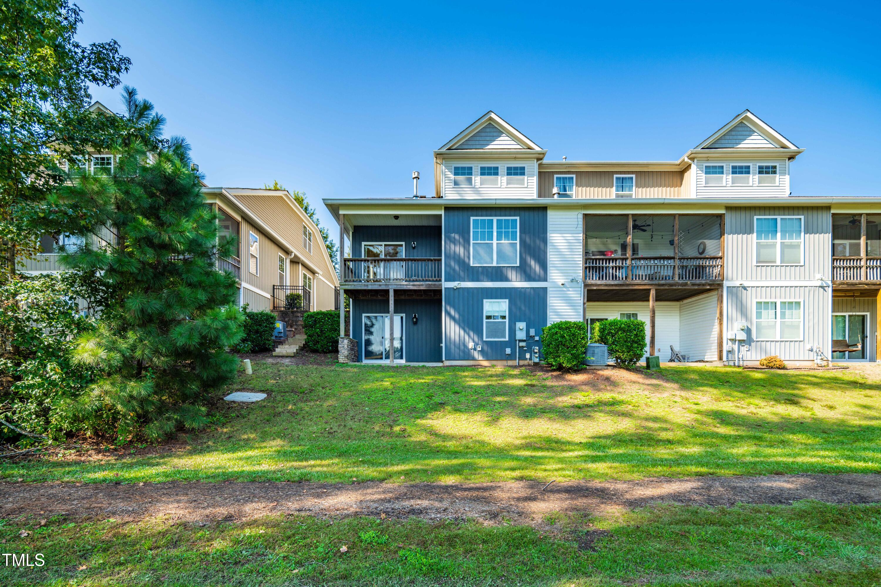 1305 Silver Beach Way Raleigh, NC 27606 - Photo 36 of 47 a view of a big house with a big yard and large trees