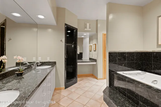 a bathroom with a granite countertop sink a toilet and shower
