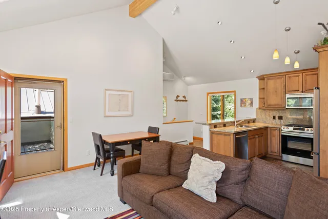 a living room with stainless steel appliances kitchen island granite countertop furniture and a kitchen view