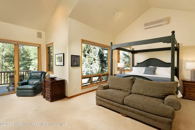 a bedroom with furniture and large windows