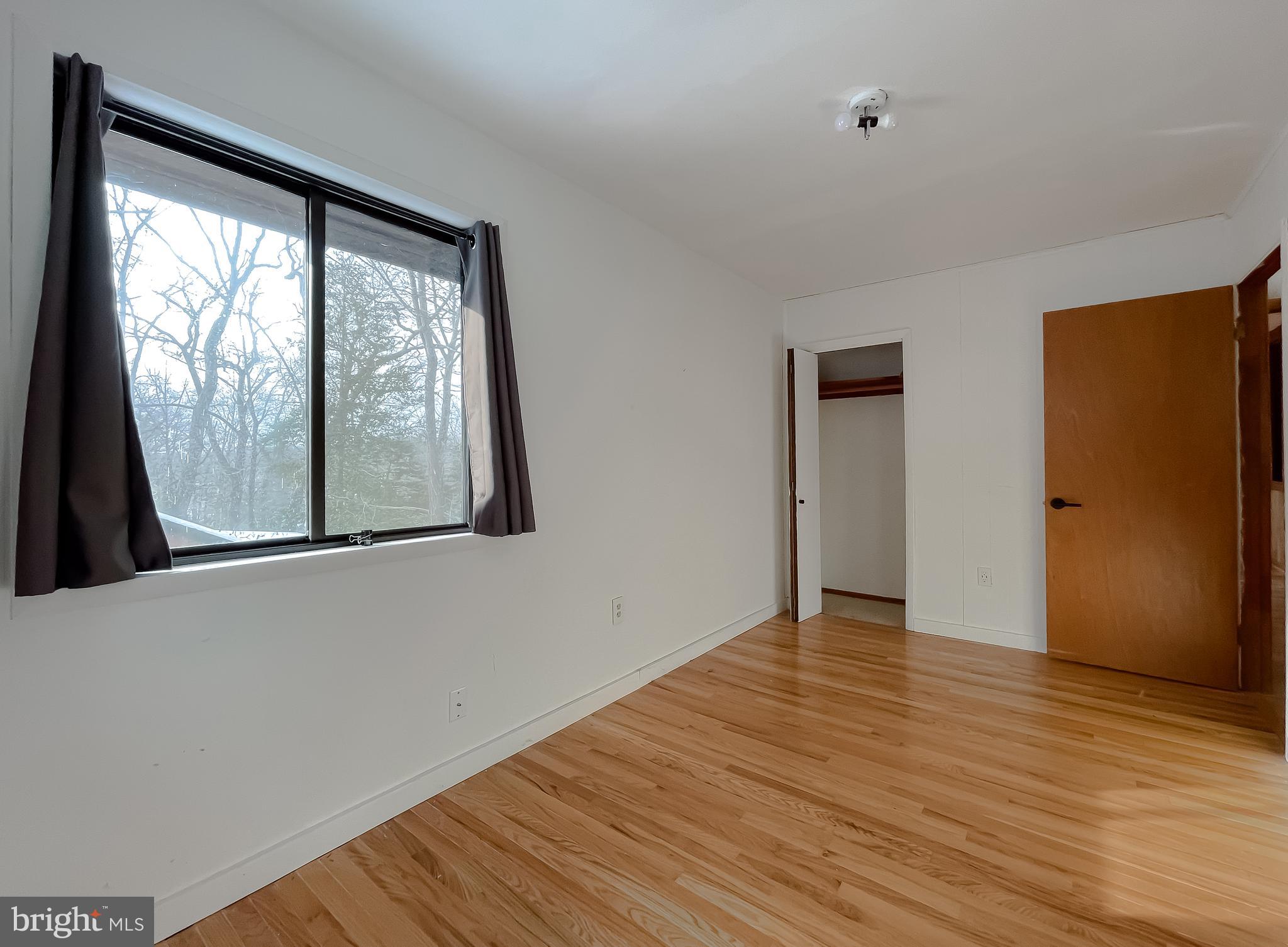 11525 Palo Alto Road Lusby, MD 20657 - Photo 52 of 74 a view of an empty room with wooden floor and a window