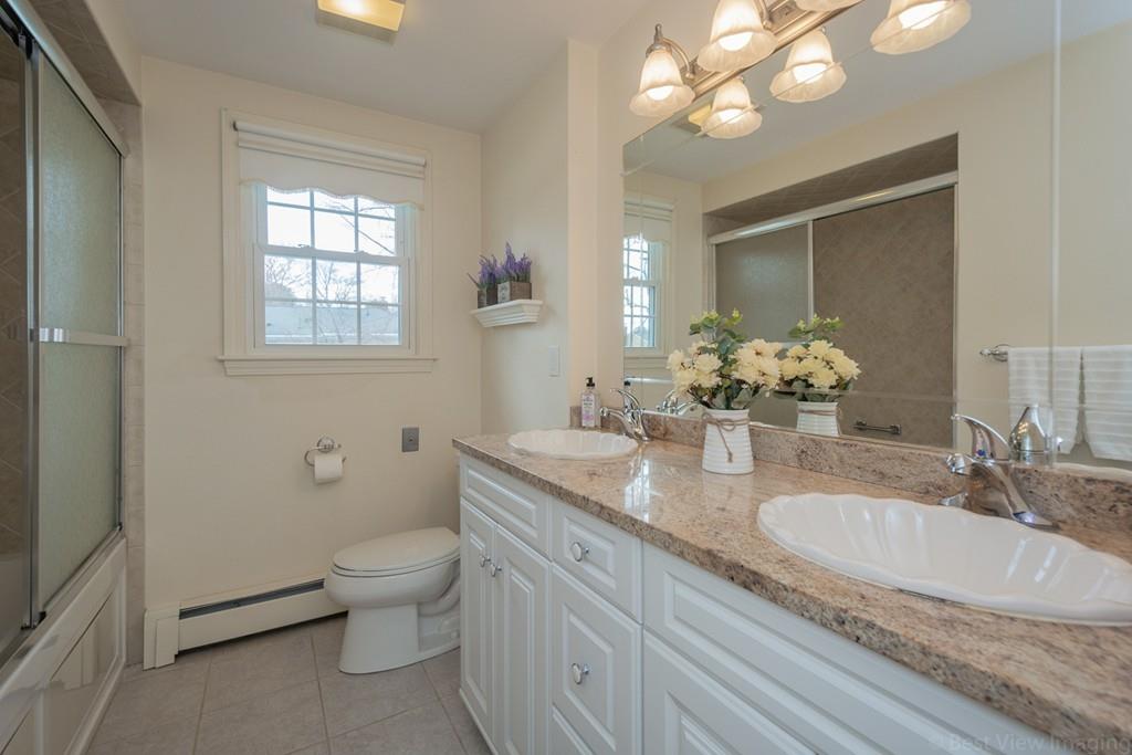 18 Harding Street Milford, MA 01757 - Photo 11 of 28 a bathroom with a granite countertop toilet a sink and a mirror
