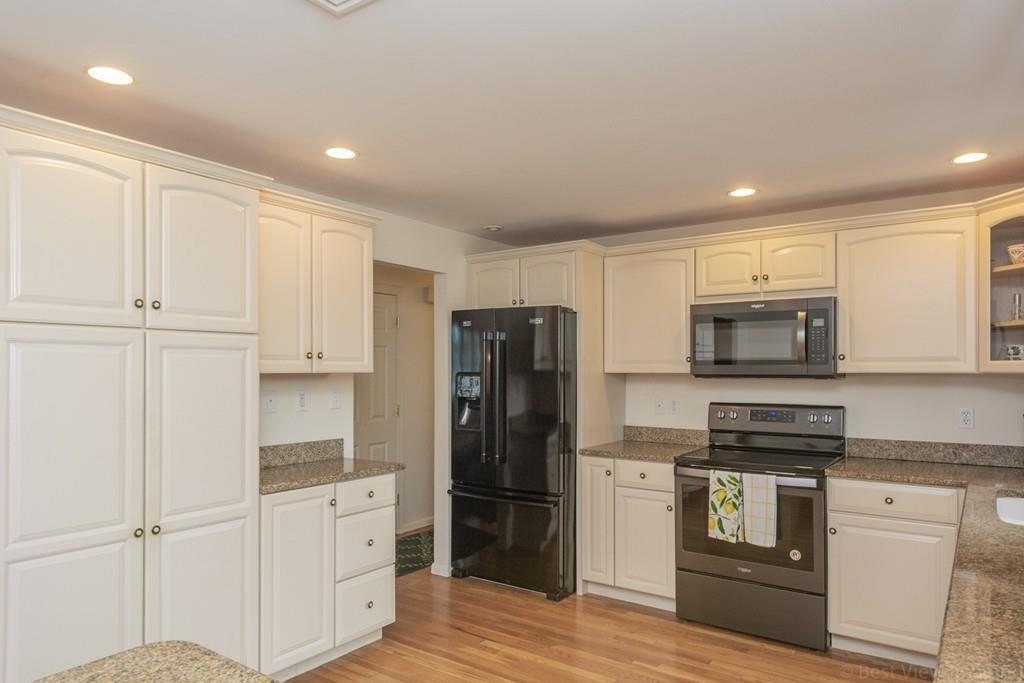 18 Harding Street Milford, MA 01757 - Photo 3 of 28 a kitchen with white cabinets and stainless steel appliances