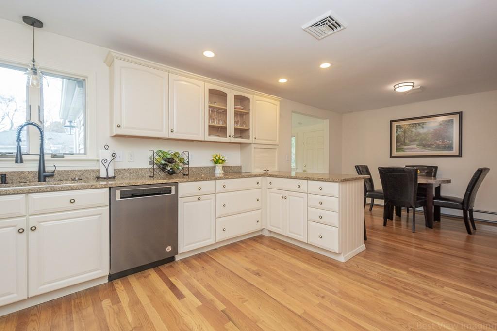 18 Harding Street Milford, MA 01757 - Photo 5 of 28 a kitchen with stainless steel appliances granite countertop a stove a sink dishwasher and white cabinets with wooden floor