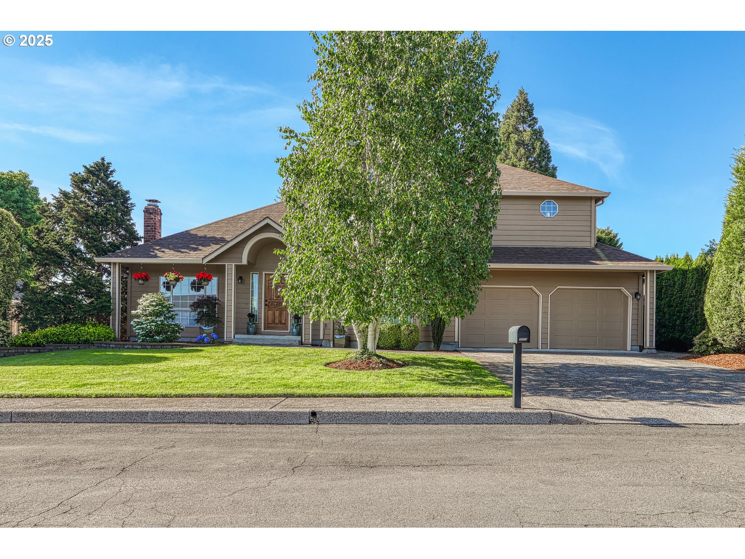 3003 Northeast 164th Street Ridgefield, WA 98642 - Photo 2 of 38 a small yard in front of a brick house with a large tree