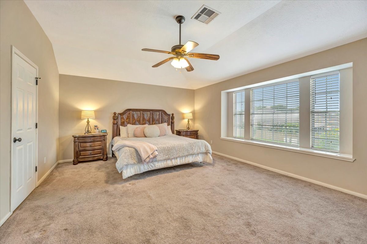 4235 Park Ridge Drive Pasadena, TX 77504 - Photo 30 of 41 a spacious bedroom with a large bed chandelier and a window
