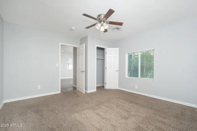 a view of an empty room with a ceiling fan