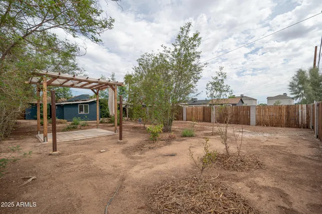 a view of a house with backyard and trees