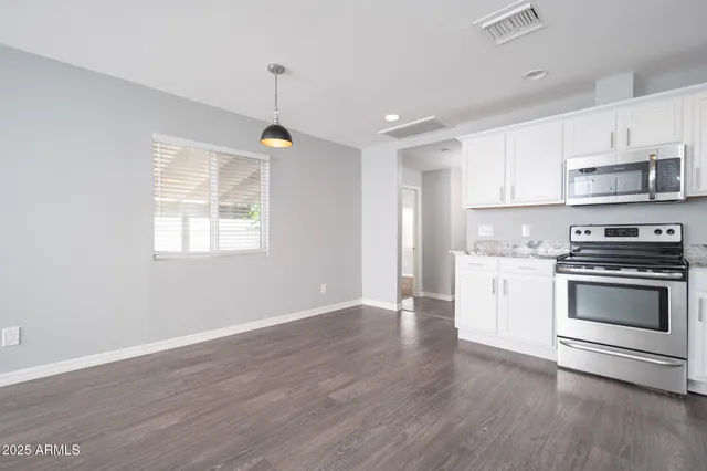 a kitchen with granite countertop a stove a sink and a refrigerator