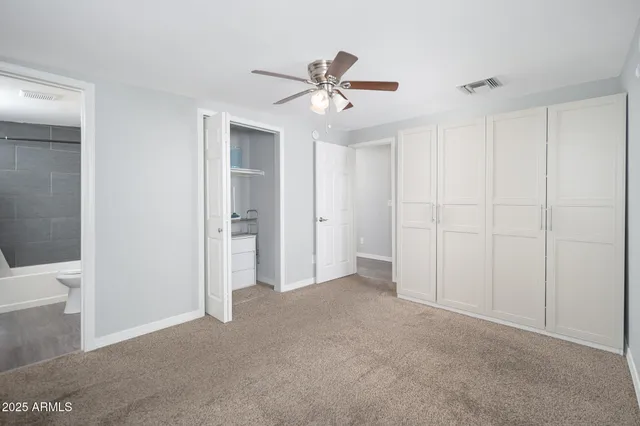 a view of an empty room and a ceiling fan