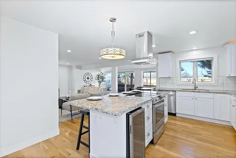 a kitchen with a stove a sink a dining table and chairs