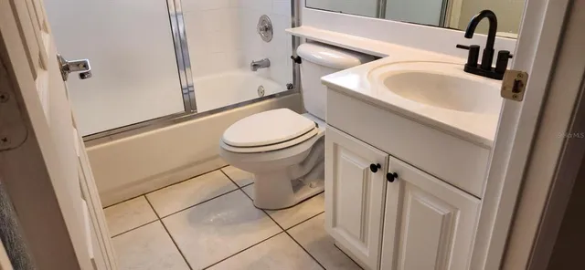 a bathroom with a glass shower door and a mirror