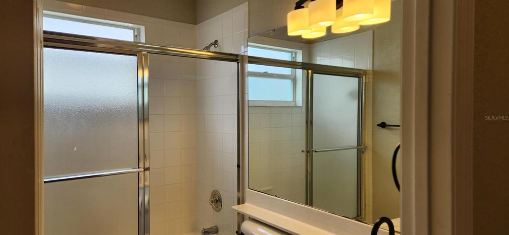 6554 Fairway Gardens Drive, Unit 6554 Bradenton, FL 34203 - Photo 16 of 25 a bathroom with a glass shower door and a mirror