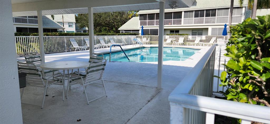 6554 Fairway Gardens Drive, Unit 6554 Bradenton, FL 34203 - Photo 25 of 25 a balcony with table and chairs potted plants with wooden floor