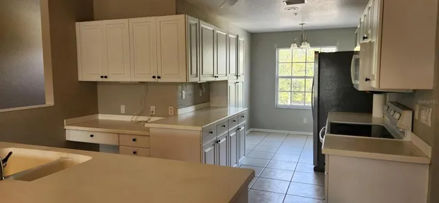 a kitchen with granite countertop a sink a stove and a microwave