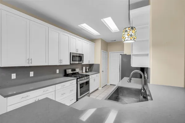 a kitchen with granite countertop a sink stainless steel appliances and cabinets