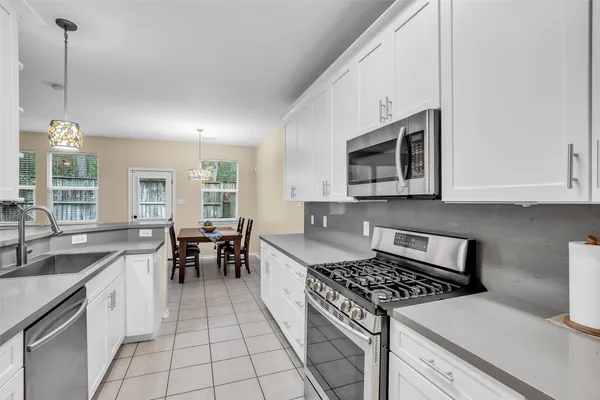 a kitchen with a stove a sink and a microwave